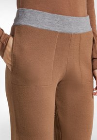 Bruine broek met een grijze jersey tailleband, twee zijzakken en een zachte, gestructureerde stof. Kenmerkt een getailleerd ontwerp.