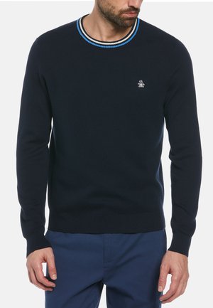 Marineblauer Strickpullover mit Rundhalsausschnitt, ausgestattet mit blau-weißen gestreiften Rippbündchen. Dezentes Pinguin-Logo auf der Brust gestickt.
