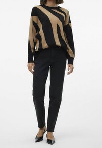 Pull rayé noir et marron en maille douce, avec des manches longues et un col rond. Associé à un jean noir taille haute et des escarpins pointus.