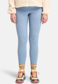 Ljusblå leggings i ett stretchigt material, åtsittande design, slätt tyg, i kombination med flerdimensionella sportskor och ribbade strumpor.