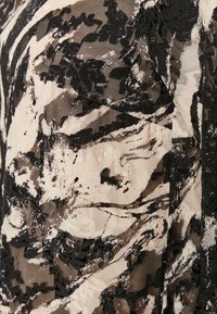Un tissu léger et transparent arbore un motif abstrait noir et beige avec des éléments texturés. Le design comprend des tourbillons et des feuilles tranchants et contrastés.