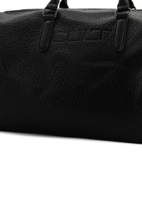 Borsa a sacca nera realizzata in pelle texturizzata, dotata di manici superiori doppi e dettaglio logo in rilievo. Chiusura a zip lungo il bordo superiore.