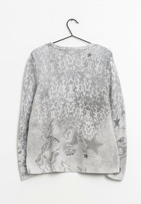 Grijze gebreide trui met dierenprint en sterrenmotieven. Zachte textuur; ronde hals; lange mouwen; ongelijkmatige zoom. Hangt aan een zwarte haak.