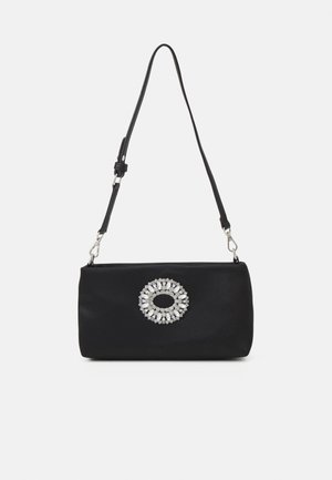 Sac à bandoulière rectangulaire noir avec sangle réglable et une décoration circulaire en strass argenté centrée sur le devant.