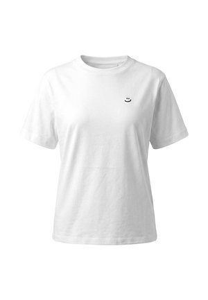 T-shirt blanc à manches courtes et col rond avec un petit logo noir de visage souriant sur la poitrine gauche.