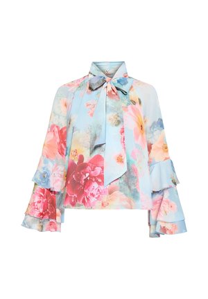 Kwiecista bluzka na pastelowo niebieskim tle, z falbanami na rękawach, kołnierzykiem z kokardą oraz żywymi różowymi, czerwonymi i niebieskimi wzorami kwiatów. Jedwabista tekstura.
