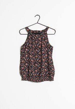 Ærmeløs bluse med blomsterprint med lyserøde og blå blomster på sort stof, hængende på en sort bøjle mod en hvid baggrund.