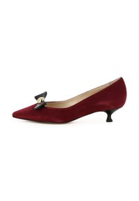 Décolleté in suede bordeaux con punta affusolata, caratterizzato da un accento in fiocco nero e dettagli in oro. Tacco kitten basso e curvato, fodera interna liscia.