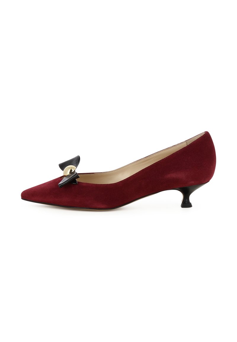 Décolleté in suede bordeaux con punta affusolata, caratterizzato da un accento in fiocco nero e dettagli in oro. Tacco kitten basso e curvato, fodera interna liscia.