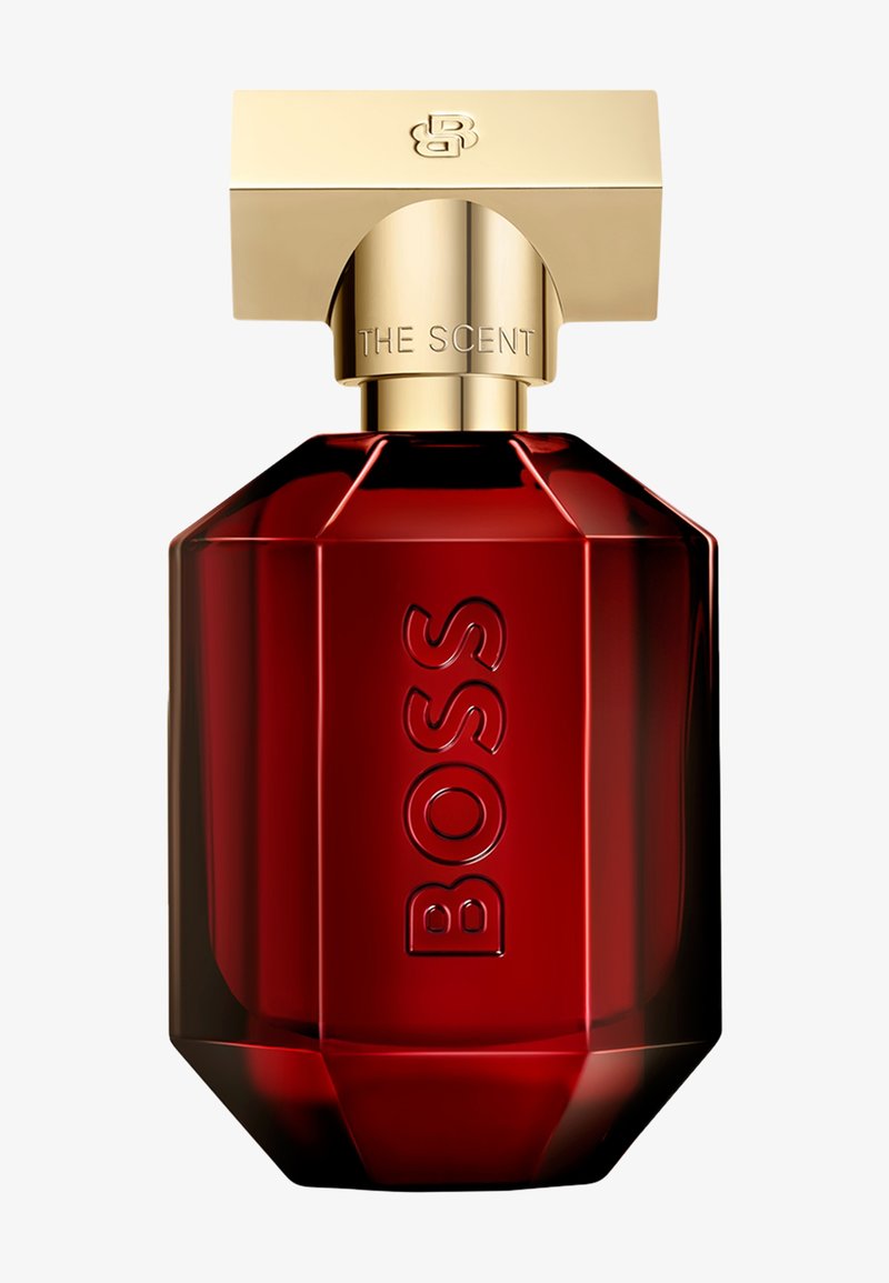 Dunkelrote facettierte Parfümflasche mit goldenem rechteckigem Verschluss, „BOSS“ auf der Flasche geprägt und „THE SCENT“ auf dem Verschlusskragen graviert.