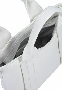 Sac à main en cuir blanc avec une surface texturée ; dispose de poignées solides et d'une poche zippée intérieure pour un rangement sécurisé.