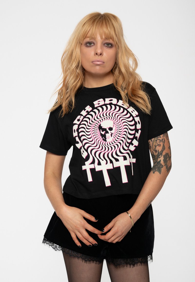 Black cropped t-shirt featuring a circular graphic with a skull and swirling pattern in pink, white, and black. Short sleeves, casual fit.