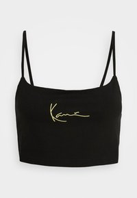 Černý crop top vyrobený z bavlny s tenkými ramínky. Vybavený žlutým vyšitým podpisem na přední straně. Hladká textura, dobře padnoucí design.