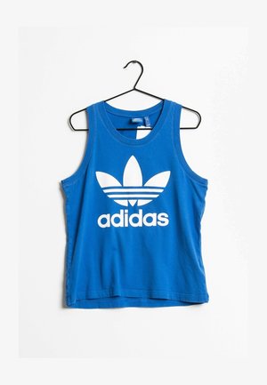 Blå ärmlös linne i bomull med stor vit Adidas-logotyp och tre ränder under logotypen. Hänger på en svart krok.