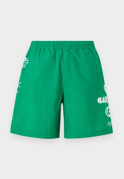 Green swim shorts with an elastic waistband, featuring white printed text and logos on the front and side. Smooth, lightweight fabric.