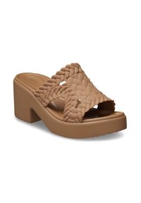 Sandales plateforme beiges avec un design de brides tressées, un talon épais, une texture lisse et un bout arrondi. Construction légère adaptée pour un usage décontracté.