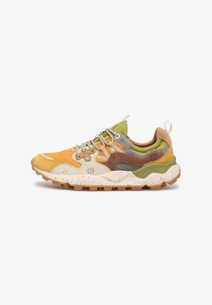 Baskets multicolores avec des panneaux beige, marron, vert et orange, fermeture à lacets sur le devant, col rembourré et semelle en caoutchouc robuste avec crampons pour l'adhérence.