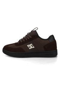 Dunkelbrauner Low-Top-Sneaker mit schwarzer Sohle, rundem Zehenbereich, Schnürsenkeln, Netz-Zunge, Wildlederdetails und weißem DC-Logo an der Seitenfläche.