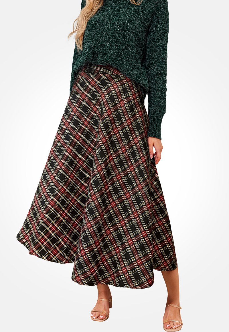 Falda de cuadros negros con líneas rojas y amarillas, diseño acampanado y textura suave, combinada con un suéter verde oscuro y sandalias.