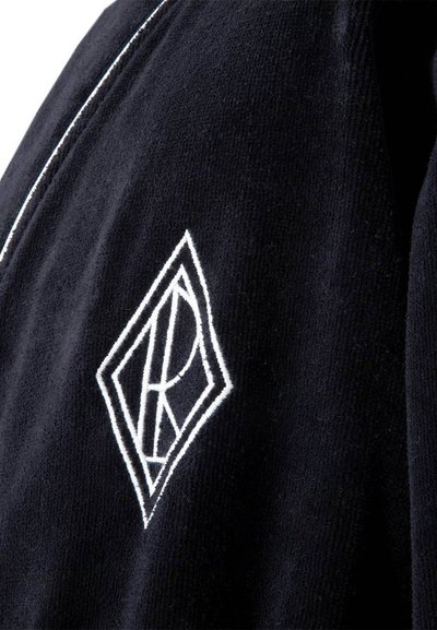 Μαύρο σακάκι από κοτρυόρι με λευκή ραφή και κεντημένο λογότυπο σε σχήμα διαμαντιού στην πάνω αριστερή πλευρά.