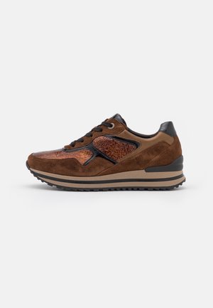 Brun ruskind og tekstureret læder sneaker med sorte snørebånd, polstret hælkant og rillede gummisål på hvid baggrund.