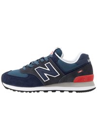 Granatowe sneakersy z siateczki i zamszu, białe i czerwone akcenty, zaokrąglony nos, płaskie sznurowanie, czarna gumowa podeszwa oraz logo "N".