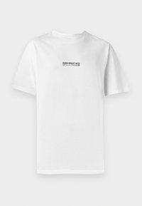 T-shirt bianca in cotone con maniche corte, caratterizzata da un testo grafico nero: "BRILLA FORTE CON SOGNI METALLICI" al centro frontale.