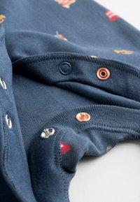 Navy-blaues Baumwollkleidungsstück mit Rundhalsausschnitt und Druckknopfverschluss, detaillierten Mustern und weichtexturiertem Stoff.
