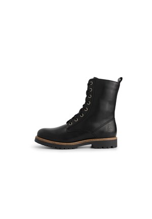 Zwarte leren veterschoenen met een ronde neus, tan accent rondom de zool, en contrasterende metalen veterogen en een lusvormige trekstrip aan de bovenkant.