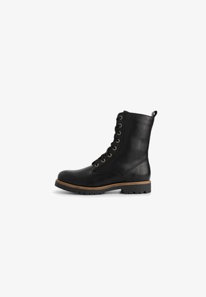 Zwarte leren veterschoenen met een ronde neus, tan accent rondom de zool, en contrasterende metalen veterogen en een lusvormige trekstrip aan de bovenkant.