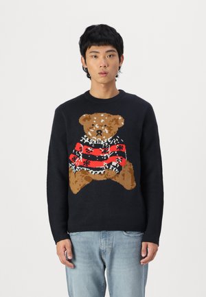 Maglione blu navy a maglia con un grande disegno di orso, decorato con un maglione a righe rosse e nere. Collo e polsini a coste. Vestibilità casual.