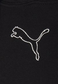 Tessuto nero con un logo Puma ricamato in bianco. Il logo rappresenta un puma che salta, circondato da uno sfondo a maglia texture.