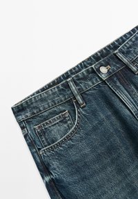 Jeans di denim blu che mostrano la parte anteriore superiore con bottone, passanti per cintura e dettagli della tasca anteriore su uno sfondo bianco.