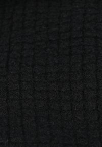 Tissu noir texturé avec un motif à carreaux, présentant une surface douce et légèrement duveteuse, idéale pour diverses applications textiles.