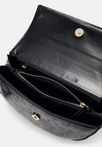 Borsa a mano in pelle nera con finitura lucida, motivo logo in rilievo, chiusura a scatto magnetica e scomparti multipli, compresa una tasca con cerniera.