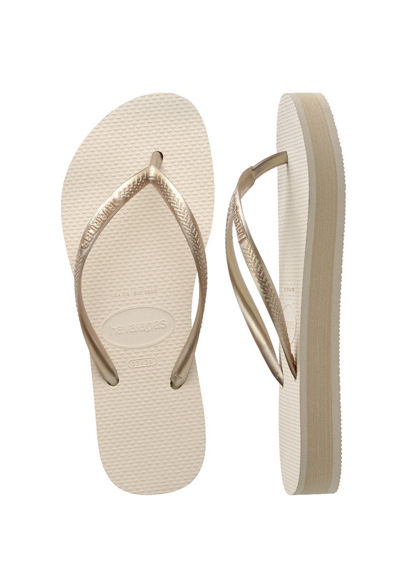 Ruske rubber-based flip-flop sandaler med teksturerte lysebeige såler. Tanga-stropper har en fletningmønster og har en liten kile for ekstra høyde.