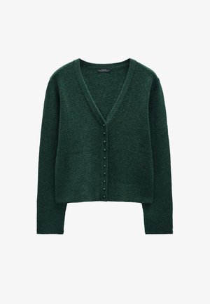 Ciemnozielony sweter z dzianiny, z dekoltem w serek, długimi rękawami i rzędem guzików z przodu. Miękka tekstura, krótki fason.
