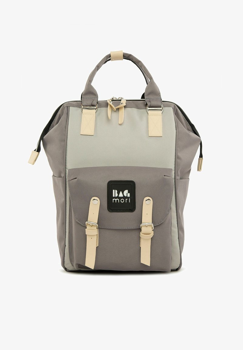 Grijze stoffen rugzak met dubbele bovenhandvatten, beige accenten, voorvak met klep en logo patch; heeft een gestructureerd ontwerp.