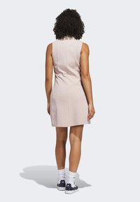 Vaaleanpunainen hihaton mekko, jossa on istuva malli, sileä rakenne ja huomaamaton takasauma. Käytetään valkoisten sukkien ja tummien lenkkareiden kanssa.