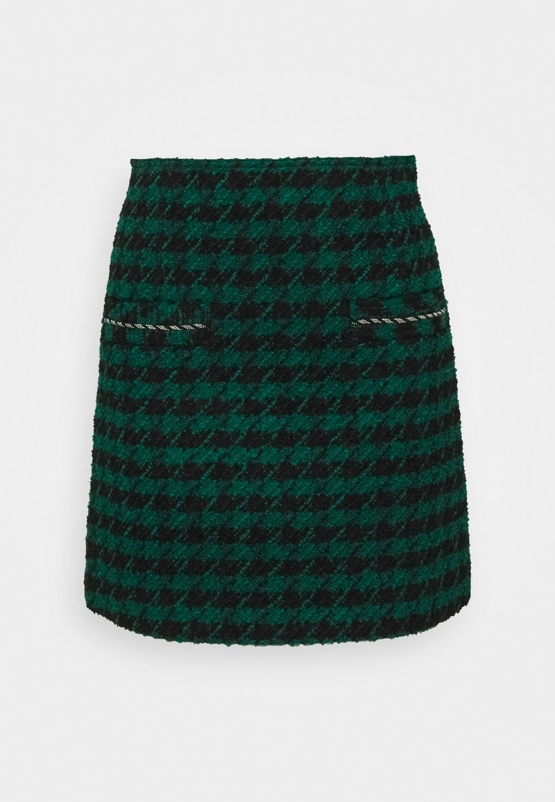 Zelená a černá sukně s houndstooth vzorem a texturovanou tkaninou. Má dvě přední kapsy s kontrastními lemy, délka nad kolena.