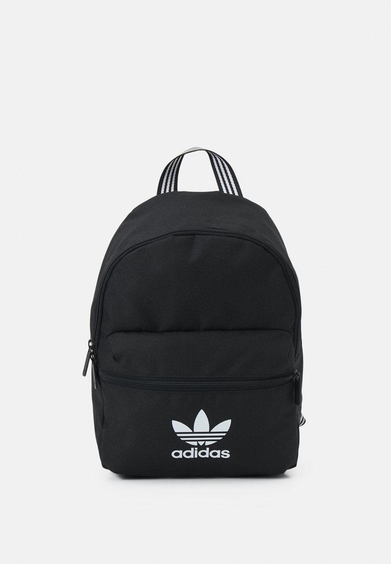Sac à dos noir Adidas avec poche avant zippée, logo Adidas trefoil blanc et poignée supérieure rayée noir et blanc sur fond uni.