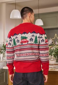 Red knitted sweater featuring winter landscape patterns, including trees, houses, and cars. Ribbed cuffs and hem, multi-colored geometric designs.