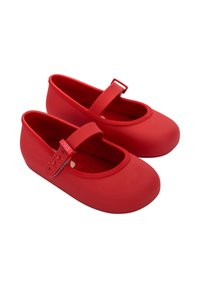 Scarpette da balletto rosse in gomma con punta arrotondata, suola piatta e una fascia sul collo del piede; rivestimento testurizzato e design senza cuciture.