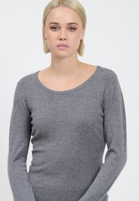Maglione grigio a maniche lunghe realizzato in morbido tessuto lavorato a maglia. Presenta un ampio scollo a giro e una silhouette aderente per un look slanciato.