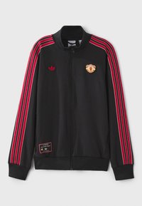 Black athletic jacket with red and white stripes, embroidered Adidas logo, Manchester United patch, and zip closure. Features ribbed collar and cuffs.