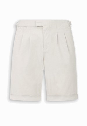 Pantaloncini beige chiaro su misura con pieghe frontali, orlo risvoltato e regolatori con fibbia laterali.