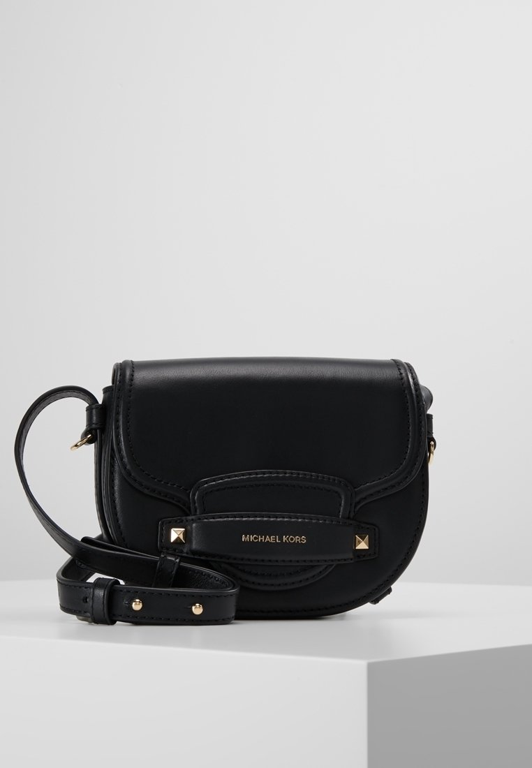 Sac bandoulière en cuir noir par Michael Kors, avec matériel doré, une forme structurée et un rabat avant avec des accents cloutés. Sangle ajustable incluse.