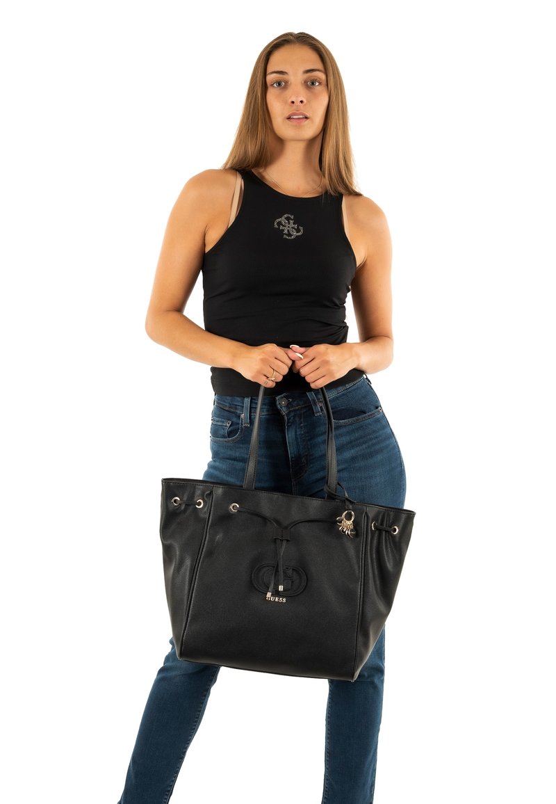 Zwarte lederen tote bag met twee handvatten, voorzien van een trekkoordsluiting, metalen accenten en een logo-detail aan de voorkant.