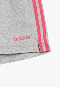 Gray athletic shorts made of cotton blend, featuring pink side stripes and an embroidered logo at the hem. Soft texture, casual design.