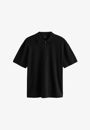 Sort polo-shirt lavet af blødt stof, med en klassisk krave og en kort lynlås foran. Korte ærmer og afslappet pasform.